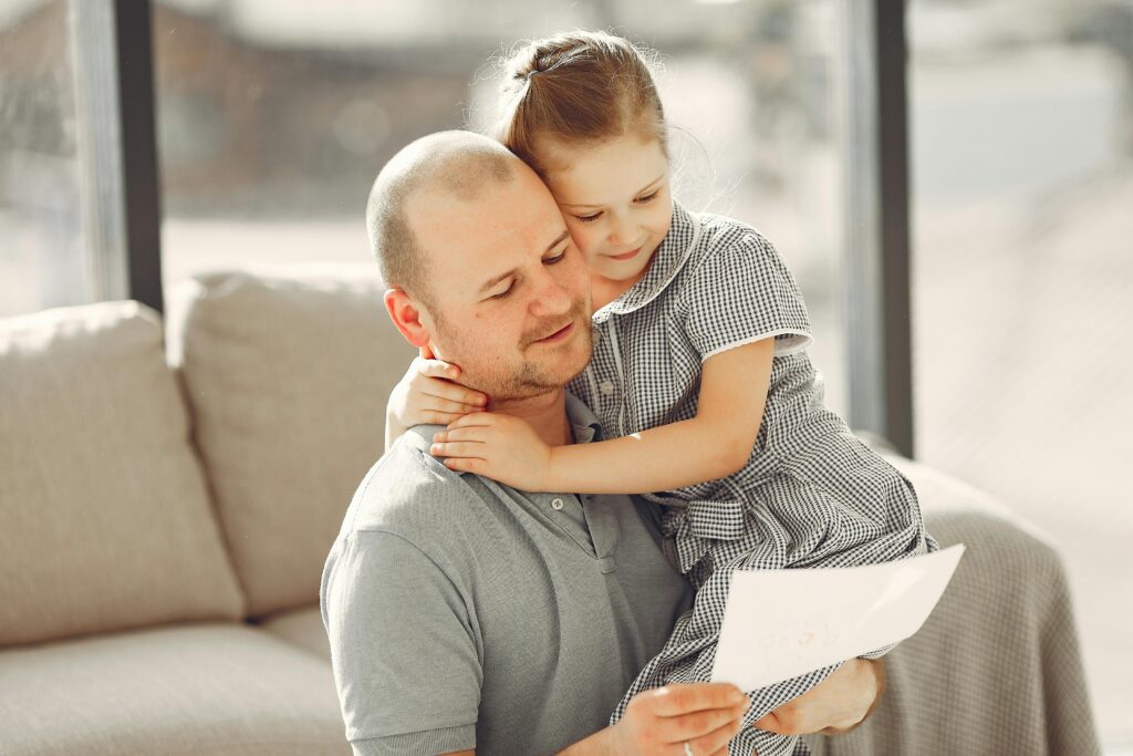Apuka átöleli a lányát és együtt olvasnak egy papírlapot